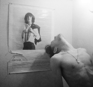 Robert-Mapplethorpe-in-front-of-his-cover-for-Patti-Smith’s-Horses-c.-1975