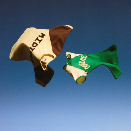 Two colorful fabric banners fluttering in the wind against a clear blue sky